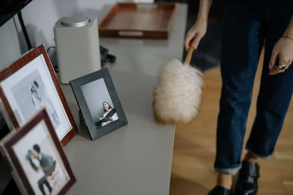 Minimalist room with a person cleaning a chair using a sponge and cleaning product.